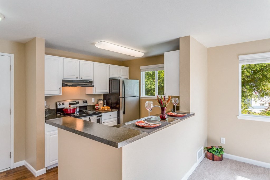 a kitchen with a island and a stove and a refrigerator at Springfield, Renton, 98055