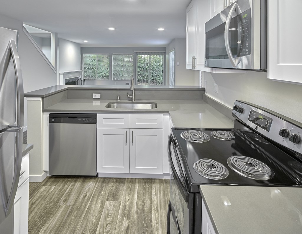 a kitchen with white cabinets and a stove and a microwave at Edmonds Gateway, Edmonds, 98026