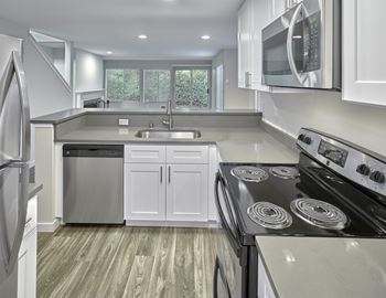 a kitchen with white cabinets and a stove and a microwave