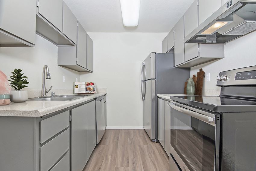 University Glen Kitchen Kitchen with fridge, oven with cooktop, dishwasher, and sink. Upper and lower cabinets on both sides.