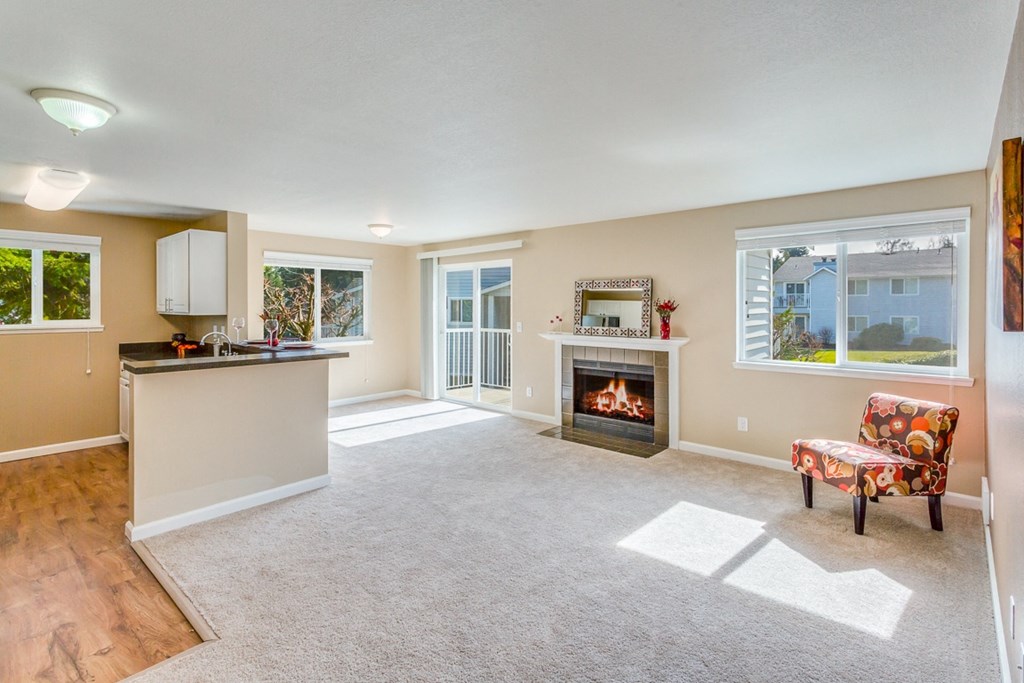 an empty living room with a fireplace and a kitchen at Springfield, Renton, WA 