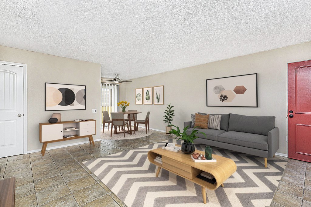 Apartment living room showing the entry door, large couch, coffee table and the dining area at Pacific Sands, San Diego, CA