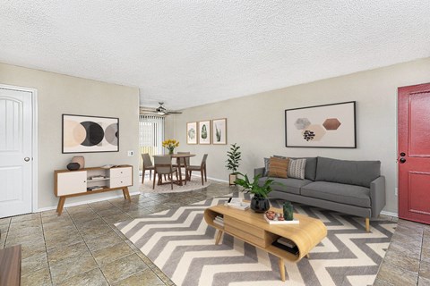 Apartment living room showing the entry door, large couch, coffee table and the dining area at Pacific Sands, San Diego, CA