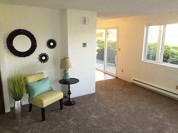 Living room Entry with chair and small table, wall decor and a sliding glass door to the patio are visible. - Photo Gallery 2