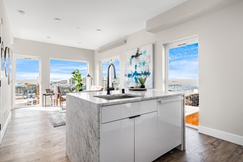 Living Area Corner home with open layout kitchen looking into the living room, 4 large floor-to-ceiling windows with city views. - Photo Gallery 4