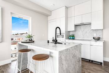 Kitchen Kitchen with waterfall marble island, floor-to-ceiling cabinets, undermount sink, flat stove top, oven, microwave, dishwasher. - Photo Gallery 2
