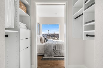 Walk-in closet with a custom shelving system, opens to the bedroom with a view of the Space Needle. - Photo Gallery 9