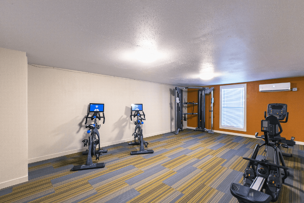 Fitness center with one window, stationary bikes, cable machine and rowing machine..at Park View Apartments, Wenatchee