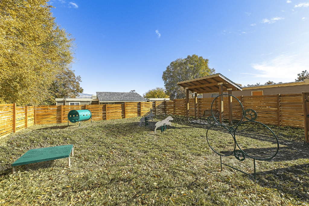 Large grassy dog run area with fence and tunnels at Park View Apartments, Wenatchee Washington