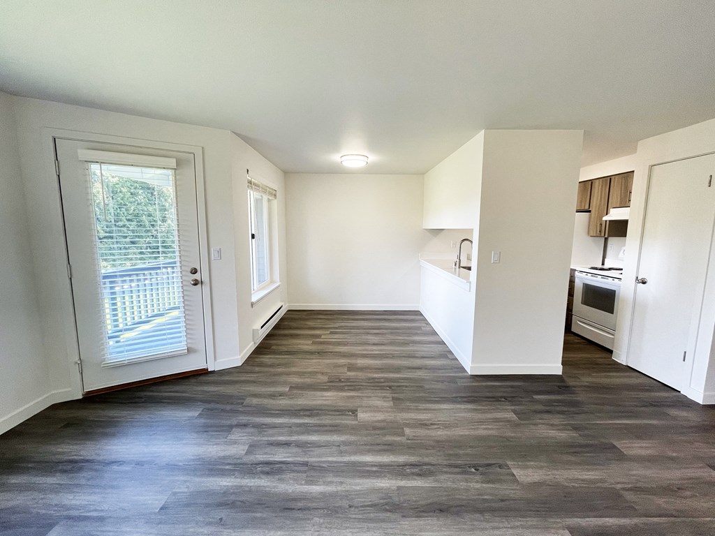 an empty living room and kitchen with white walls and wood flooring  at The Trail, Snohomish