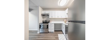 A modern 1 Bed 1 Bath kitchen with stainless steel appliances and white cabinets at Peak 88 in Renton, WA.