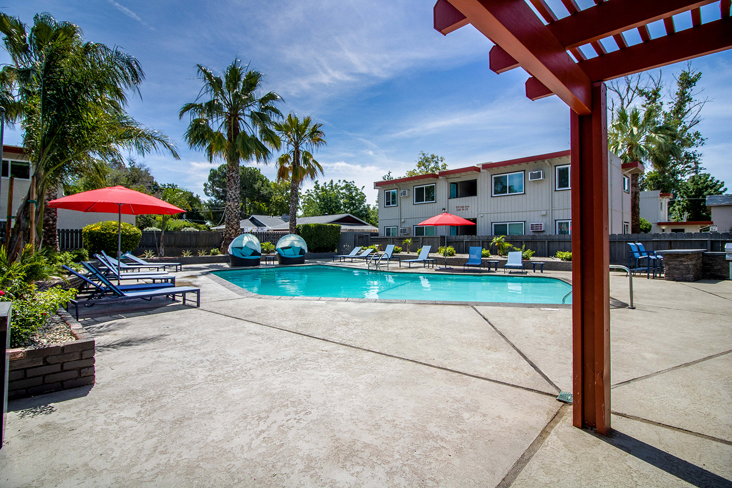 Resort style pool with lounge chairs, umbrellas, covered seating and BBQ at Woodland Village Apartments , California, 95695