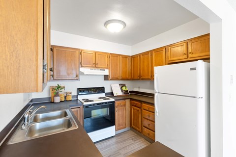 A kitchen with wooden cabinets and a white refrigerator.