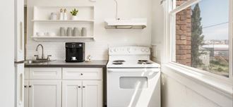 a small kitchen with white cabinets and a window - Photo Gallery 2