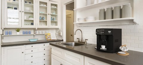 a kitchen with white cabinets and a black counter top  at South Court, Bremerton, 98337