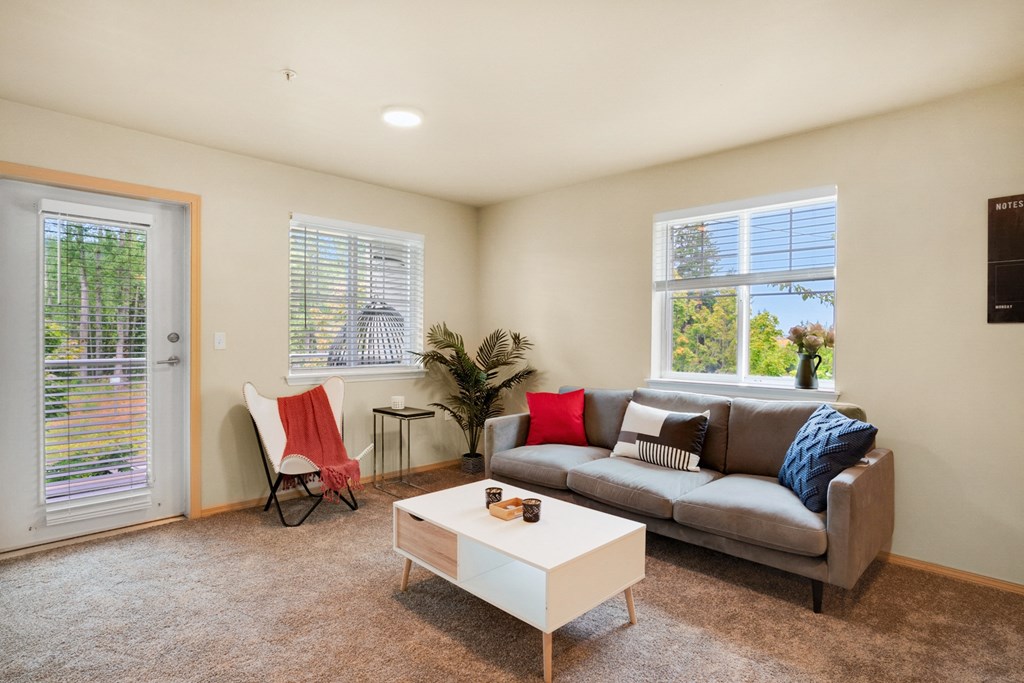 a living room with a couch and a coffee table, two windows and a glass exterior door at Sky Vue, Washington