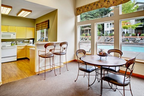 A kitchen with a table and chairs in front of a window.