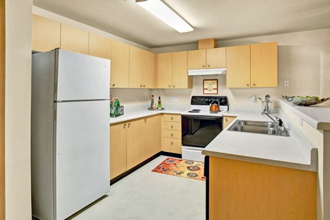 Kitchen with light wood cabinets at Sunrise Lane Apartments Everett WA
