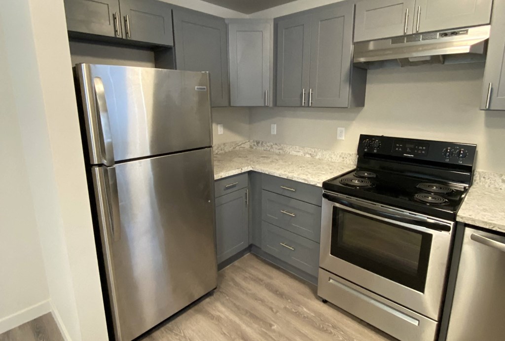 a kitchen with stainless steel appliances and marble counter tops  at The Lakes Apartments, Washington, 98837