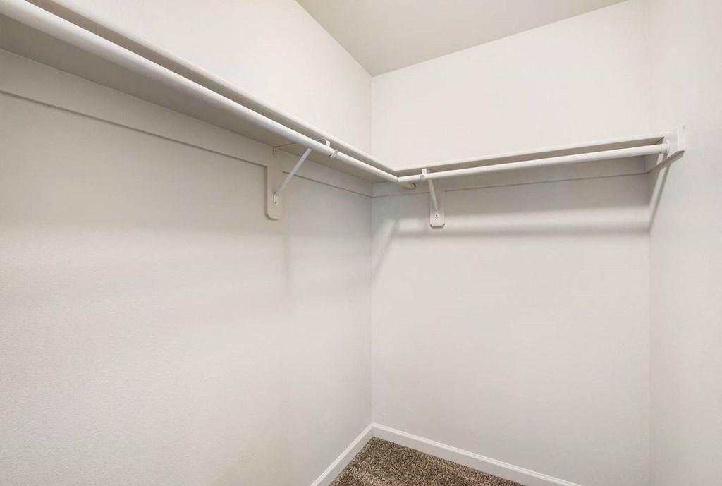L-shaped walk in closet with white walls, taupe carpet and shelf storage. at Pine Tree Park, Kennewick