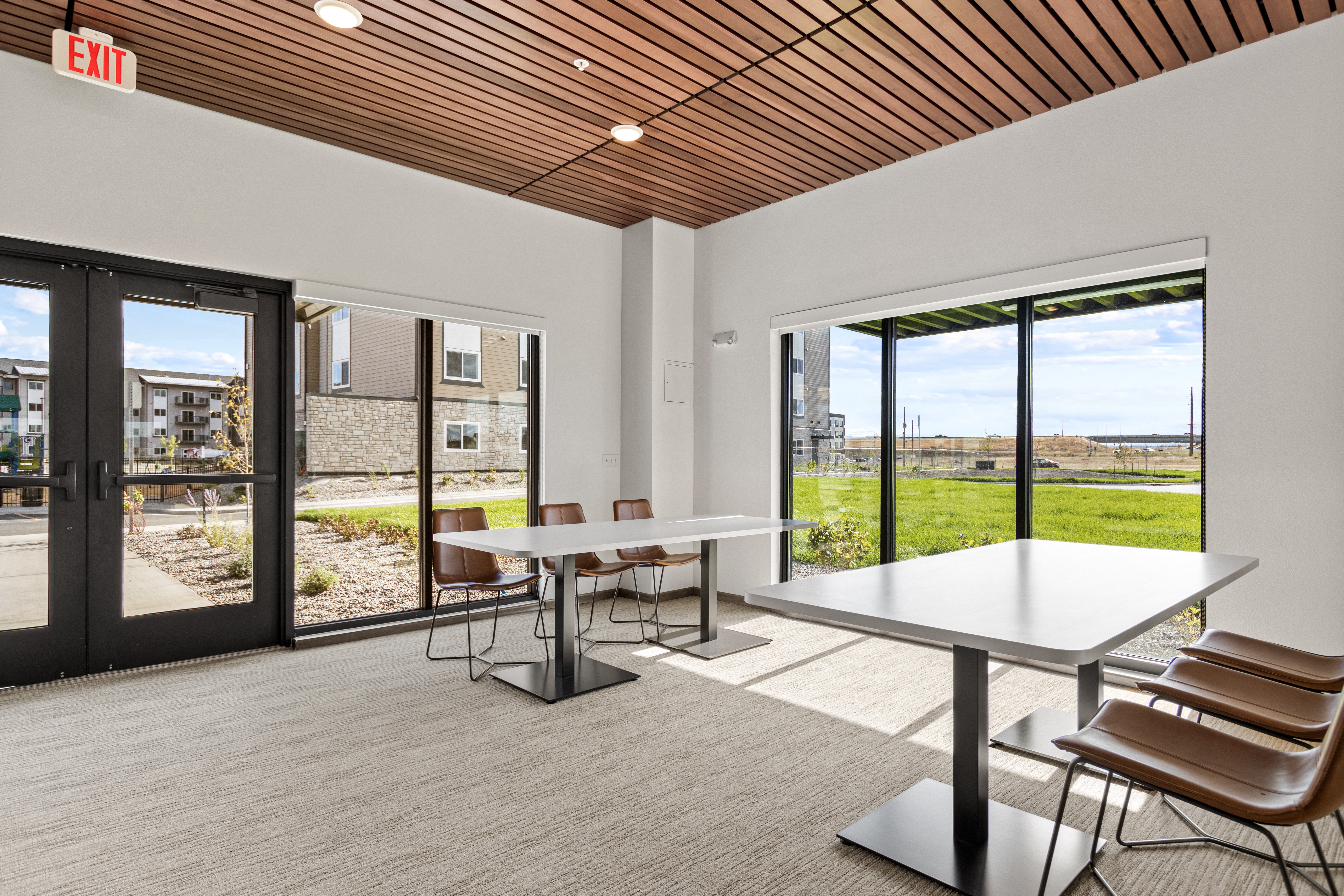 a dining room with a table and chairs in a building with glass doors