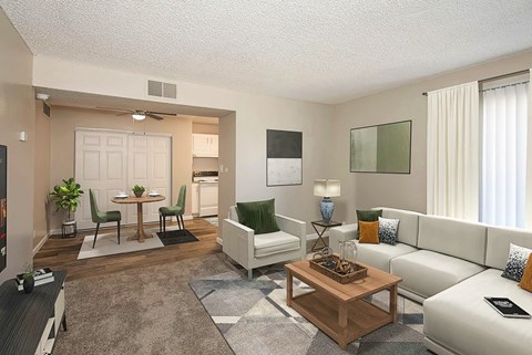 A living room with a white couch, a coffee table, and a dining table.