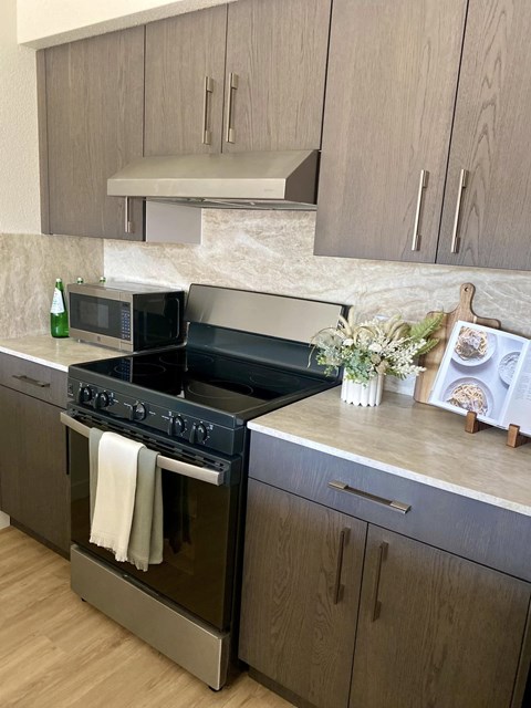 A modern kitchen with a black oven and wooden cabinets.