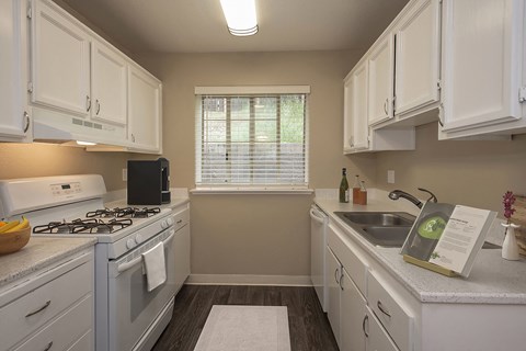 A kitchen with white cabinets and a black stove top.