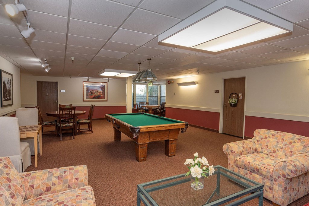 a game room with a pool table and couches at Hilltop Commons Senior Living, Grass Valley, 95945