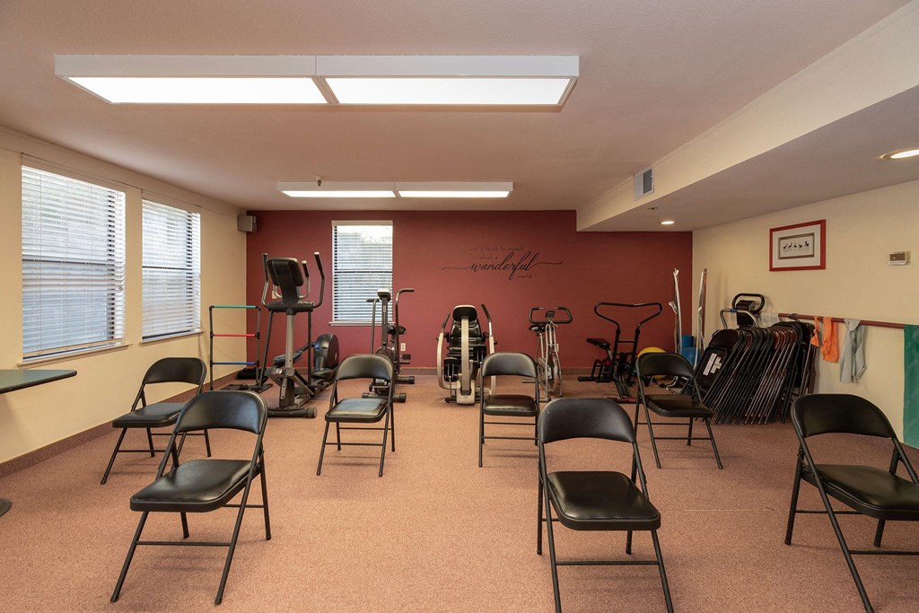 a fitness room with chairs and exercise equipment at Hilltop Commons Senior Living, Grass Valley, CA 95945