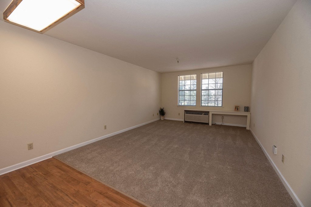 a spacious living room with hardwood floors and a window at Hilltop Commons Senior Living, Grass Valley, 95945