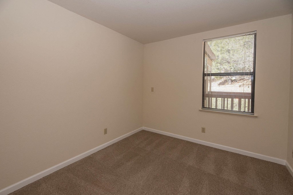 an empty room with carpet and a window at Hilltop Commons Senior Living, California