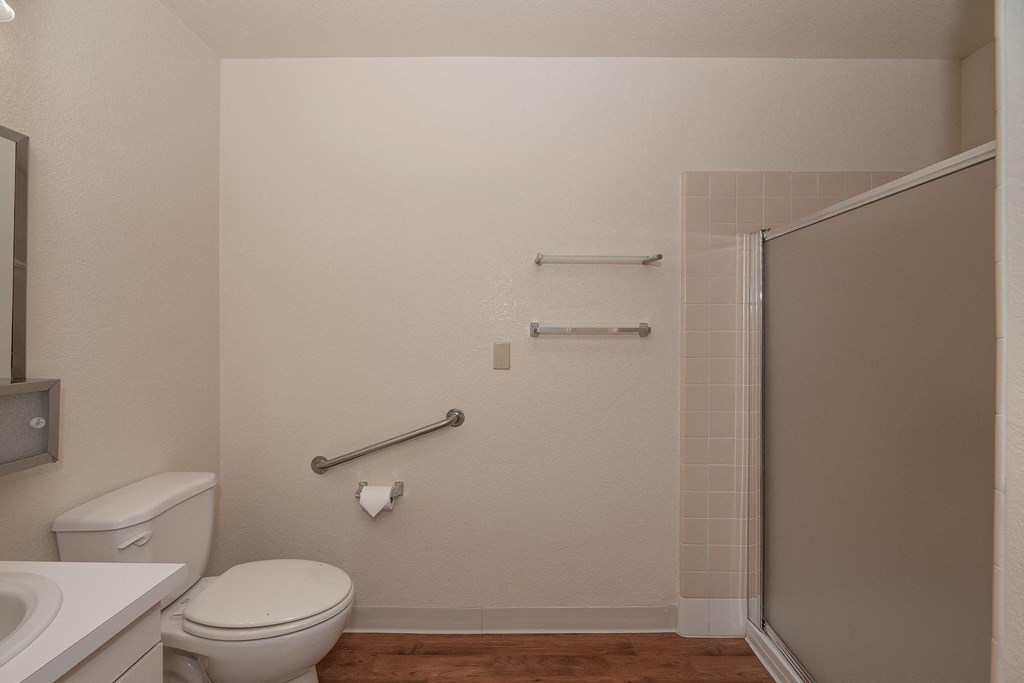 a bathroom with a toilet and a shower and a sink at Hilltop Commons Senior Living, Grass Valley, 95945