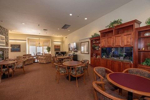 a living room with tables and chairs and a fish tank