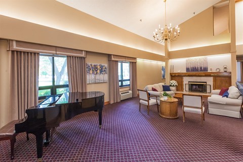 a living room with a piano and a purple carpet