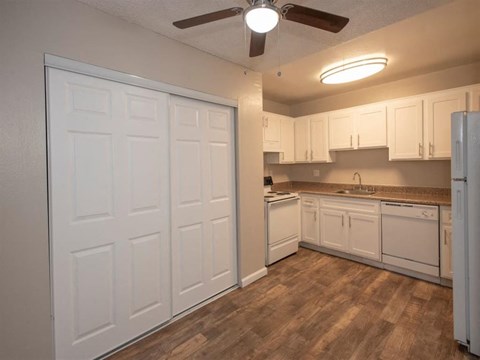 A kitchen with white cabinets and a white refrigerator.