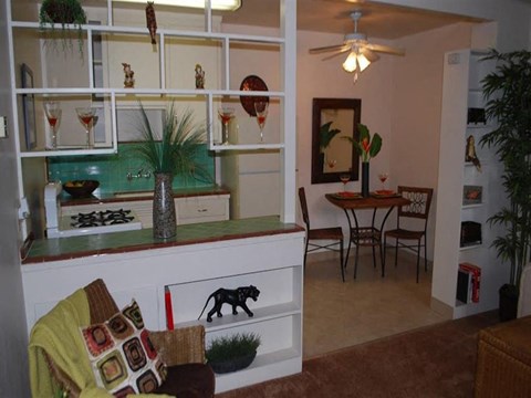 A kitchen with a table and chairs in the background.