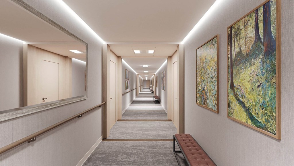 a long hallway with paintings on the wall and a bench at Hearthstone Lodge Senior Residences, California, 95602