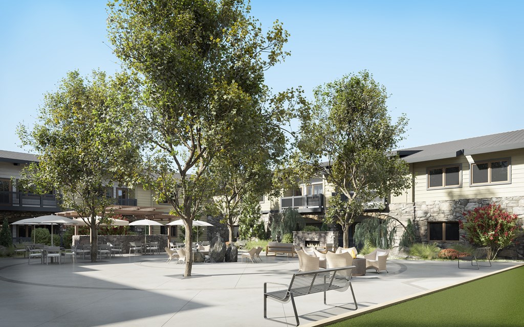a patio with chairs and trees in front of a building