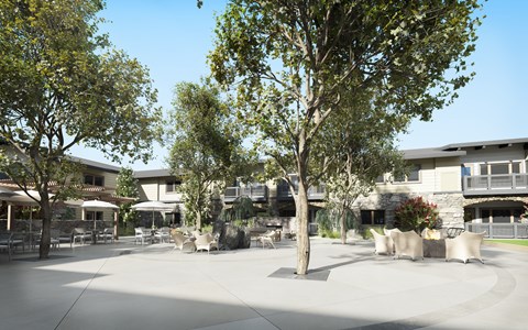 a courtyard with trees and tables and buildings in the background