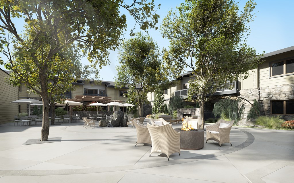 a seating area with chairs and trees in front of a building