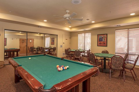 Game room with billiards and card tables at Winding Commons Senior Living Apartments, California