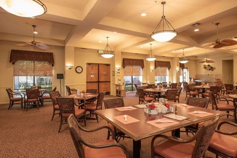 Community dining room with pendant lighting at Winding Commons Senior Living Apartments, California, 95608