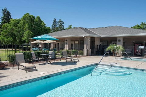 Pool area with spa and clubhouse building at Castle Vista Senior Duplex Community Apartments, Atwater
