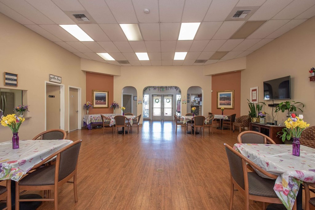 a large room with tables and chairs and a wood floor at Castle Vista Senior Duplex Community, Atwater, CA