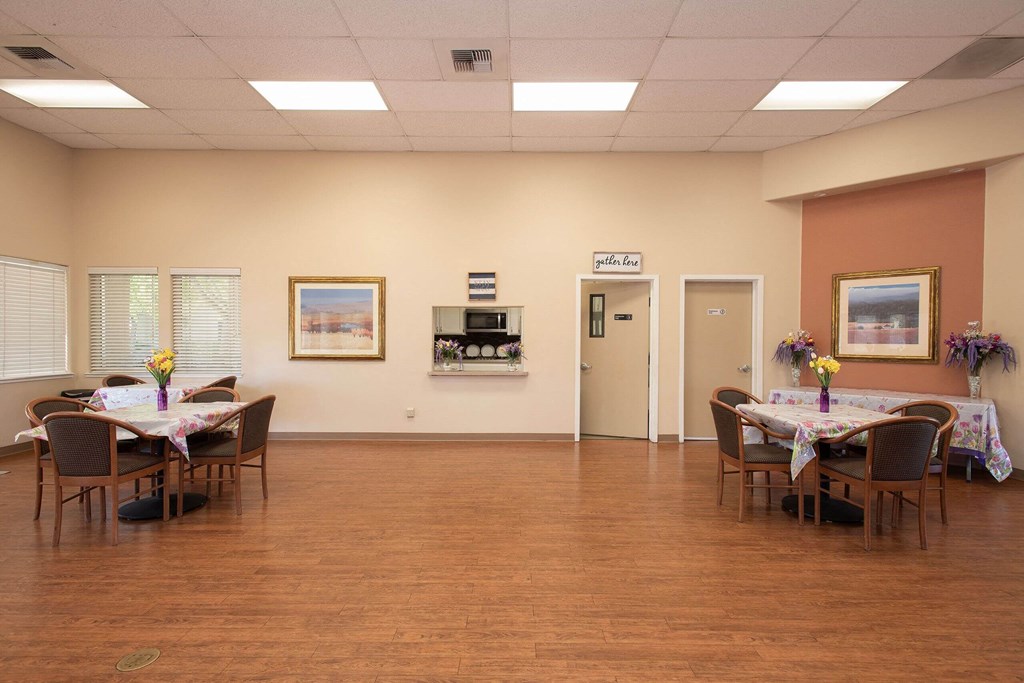 a dining room with tables and chairs in a large room with a wood floor at Castle Vista Senior Duplex Community, Atwater, CA, 95301