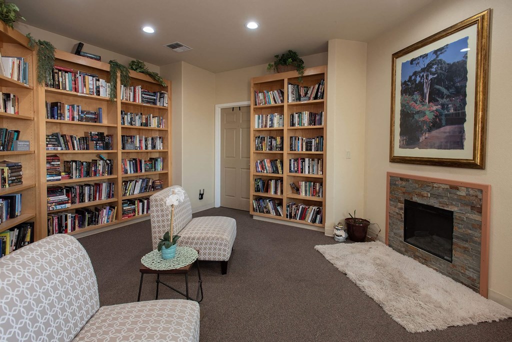 a living room with a fireplace and shelves of books at Castle Vista Senior Duplex Community, Atwater, 95301