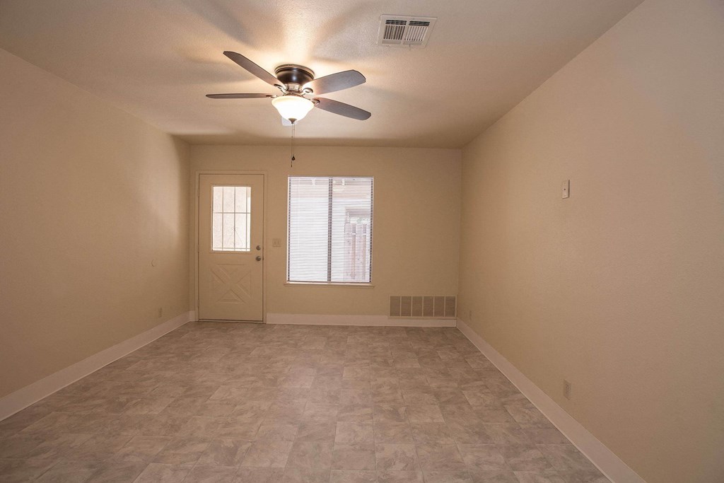 an empty living room with a ceiling fan and a window at Castle Vista Senior Duplex Community, Atwater, CA, 95301