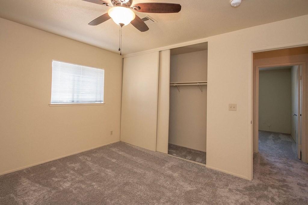 an empty living room with a ceiling fan and a closet at Castle Vista Senior Duplex Community, Atwater, CA