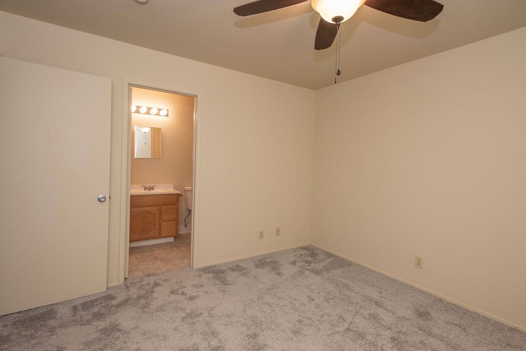 an empty bedroom with a ceiling fan and a bathroom at Castle Vista Senior Duplex Community, Atwater, 95301